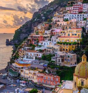 a group of buildings on a hill next to the ocean