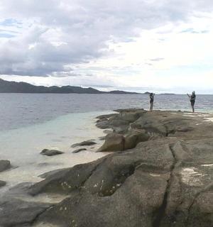 两个人站在水中的岩石上