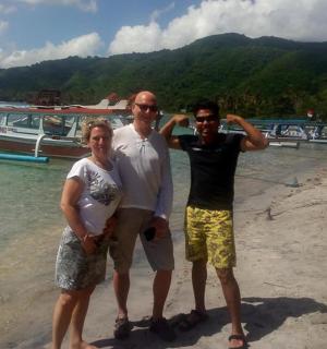 三个人站在海滩上,旁边有一条船