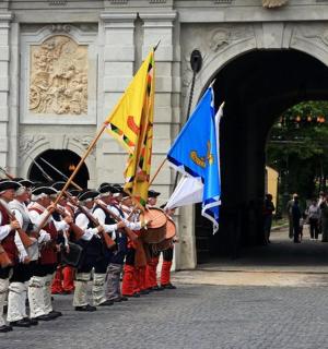 eine Gruppe von Menschen in Militäruniformen, die Flaggen halten