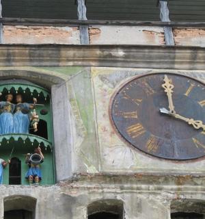 eine Uhr an der Seite eines Turms mit Figuren