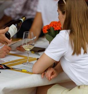 一位女士坐在桌边,手里拿着一瓶酒