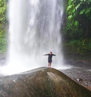 一名男子站在瀑布前