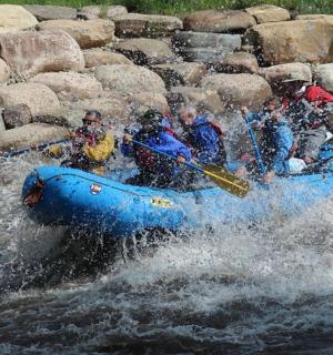 eine Gruppe von Menschen in einem blauen Floß im Wasser