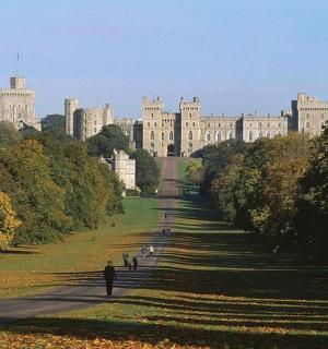 a man walking down a path in front of a large building