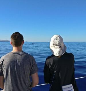 two men standing on a boat looking out over the water