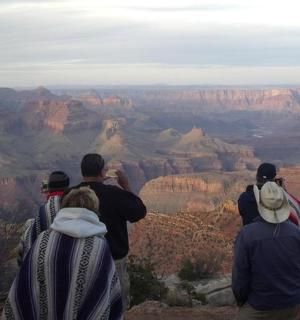 a group of people looking at the grand canyon