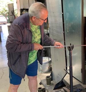 一位老人站在烤箱前