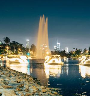 a fountain in the water with a city in the background