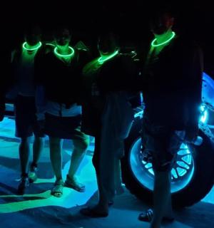 一群人围着一辆挂着霓虹灯的摩托车