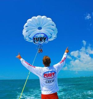 a man is flying a kite on the ocean