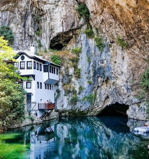 a building on the side of a mountain next to a river