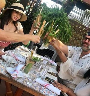 skupina lidí sedících kolem stolu s vázou