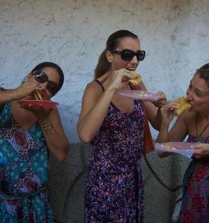 three women are eating food on paper plates