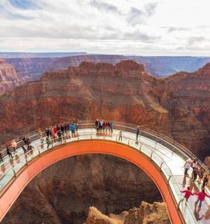 a group of people on a bridge over the grand canyon