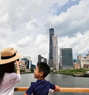 žena a chlapec stojící na lavičce a dívající se na město