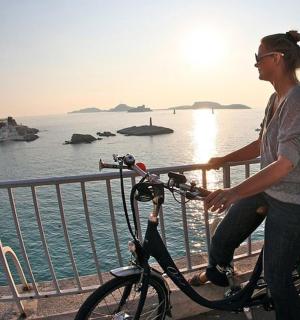 a woman riding a bike near the water