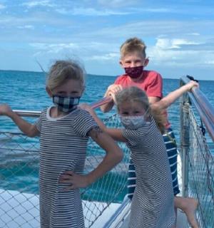 two children wearing masks on a boat in the ocean