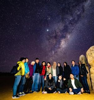 skupina lidí pózujících pro fotografii pod hvězdami