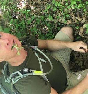 一名男子躺在地上，身边还有一株植物