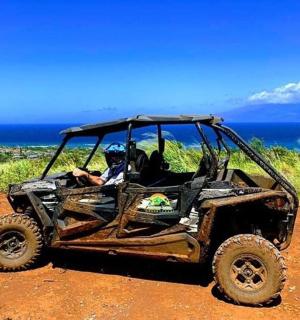 a man sitting in a muddy vehicle on a dirt road