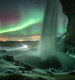 an image of a waterfall with the aurora in the sky