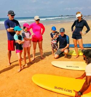 a group of people standing on a beach with surfboards