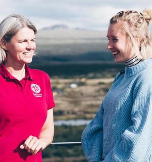 two women standing on top of a mountain