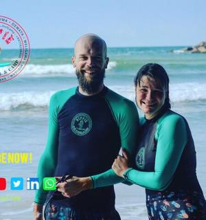 a man and a woman standing on the beach