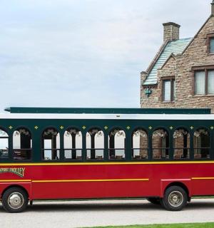 a red and green bus parked in front of a house