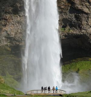 a group of people standing in front of a waterfall