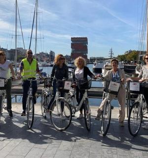 a group of people standing with bikes on a pier