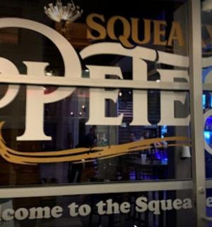 a store window with a sign that says saucer op shop welcome to the square