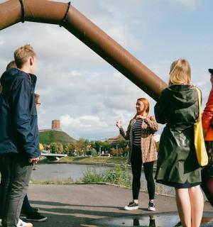 a group of people standing in front of a metal arch