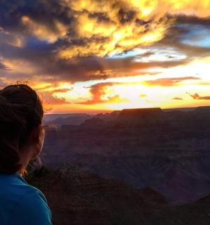 一位女士站在大峡谷看日落