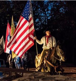 muž na koni držící americkou vlajku
