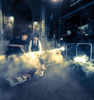 two men standing next to a dog on the street