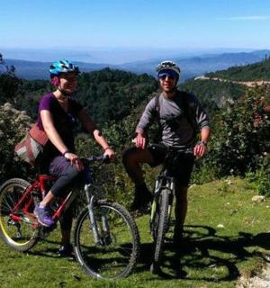 两个人在山上骑自行车，欣赏美景