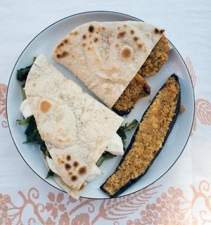 桌上有一盘食物,上面有印度薄饼和玉米