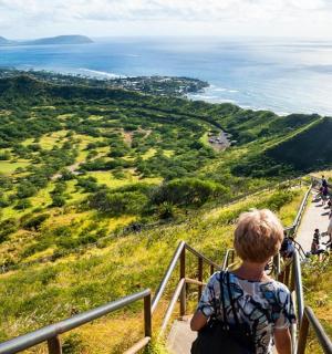 člověk stojící na kopci a dívající se na oceán