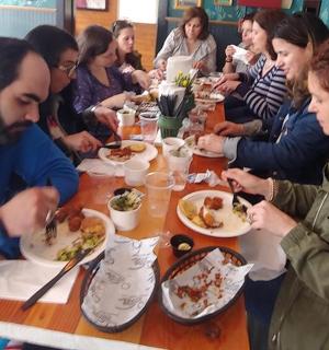 a group of people sitting at a table eating food