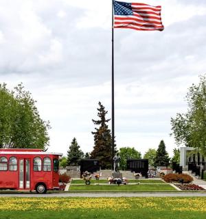 an american flag flying over a red bus