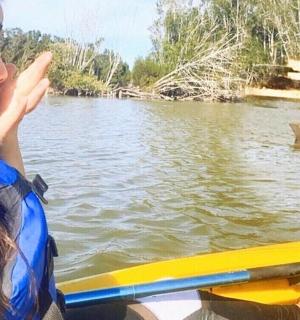 žena v kajaku dívající se na žraloka ve vodě