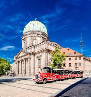 a red train in front of a building