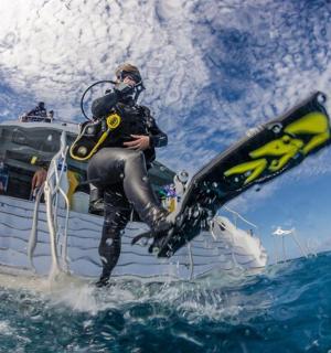 a man on a boat in the water with a surfboard