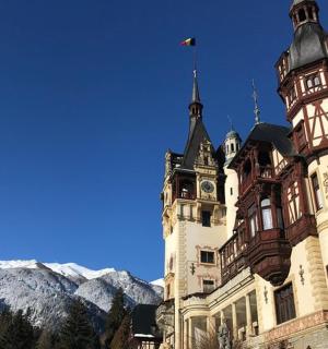 o clădire cu un turn cu ceas în fața unui munte