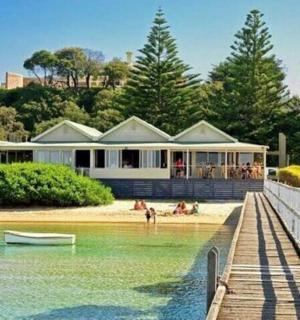 dům na pláži s lodí ve vodě