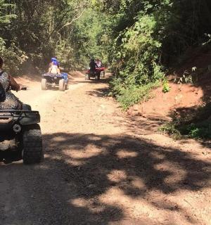 a group of people riding atvs on a dirt road