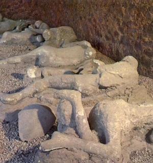 a group of statues of people laying on rocks