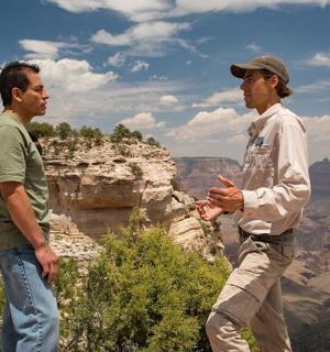 two men standing at the edge of the grand canyon